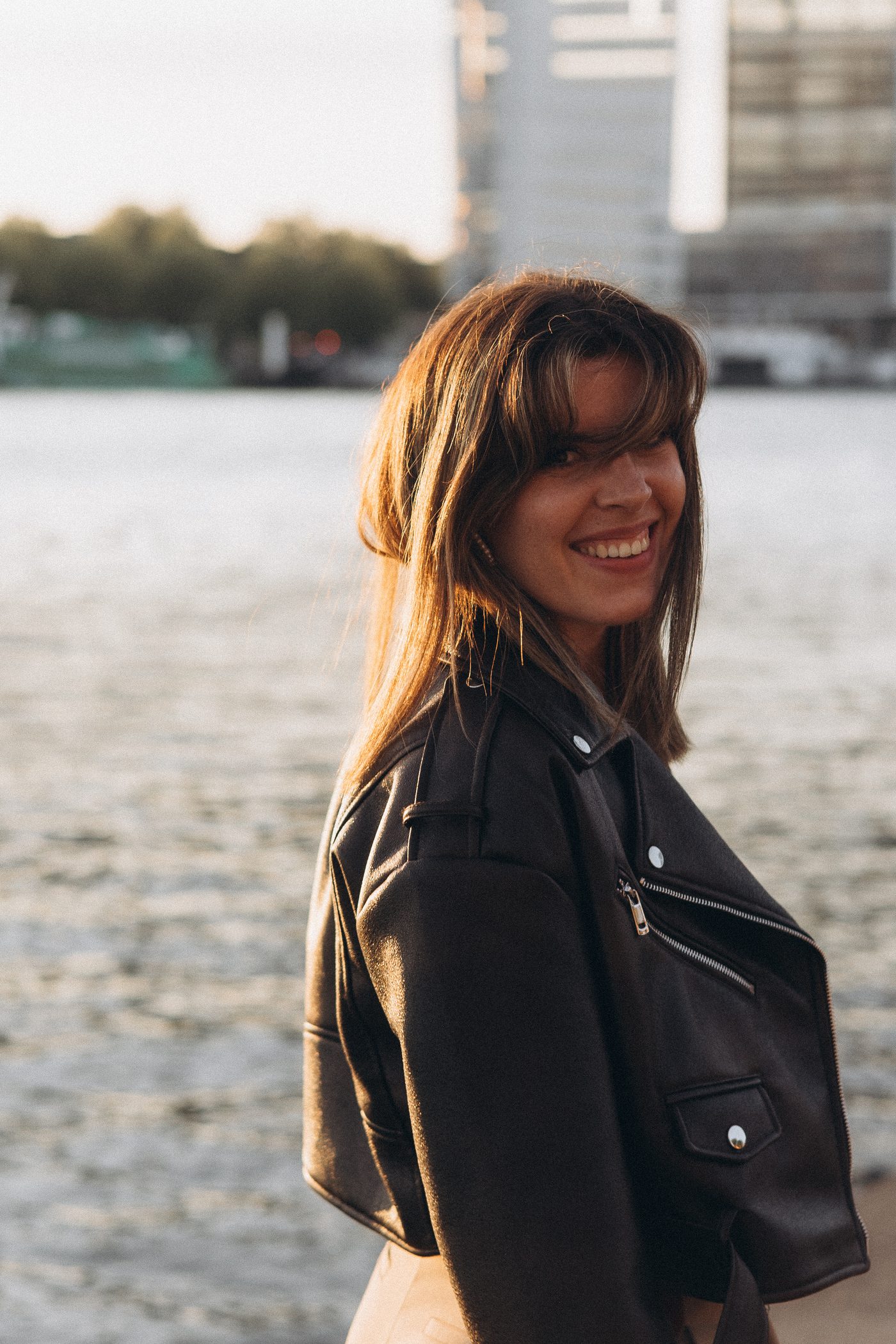Katerina smiling by the water at golden hour